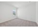 A bright, empty bedroom boasts neutral carpeting and a sun-filled window overlooking a neighborhood view at 112 Moonflower Ln # Homesite 267, Wilson's Mills, NC 27520