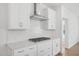 Modern kitchen with white cabinetry, quartz countertops, gas range, and stainless steel vent hood at 112 Moonflower Ln # Homesite 267, Wilson's Mills, NC 27520