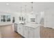 Open-concept kitchen with island, pendant lighting, stainless steel appliances, and view to living room at 112 Moonflower Ln # Homesite 267, Wilson's Mills, NC 27520