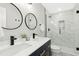 Bathroom with double sinks, round mirrors and walk-in shower with marble tile at 117 Bertie Dr, Raleigh, NC 27610