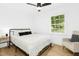 Bright bedroom with ceiling fan, white bedding and a cozy sitting area at 117 Bertie Dr, Raleigh, NC 27610