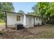 The back exterior of a white home features traditional siding, a back door and a small patio space at 117 Bertie Dr, Raleigh, NC 27610