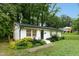 Charming, one story, white brick home, with black front door and manicured landscaping at 117 Bertie Dr, Raleigh, NC 27610