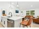 Open concept living area featuring pendant lights, leather couches and kitchen island at 117 Bertie Dr, Raleigh, NC 27610