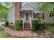 Charming home entrance with brick steps, red shutters, a brick chimney, and lush landscaping at 119 Danforth Dr, Cary, NC 27511
