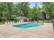 Community pool with lounge chairs and umbrellas surrounded by mature trees at 119 Danforth Dr, Cary, NC 27511