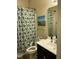 Bathroom showcasing a shower with a patterned curtain, a vanity, and a wall-mounted mirror at 119 Hunterwood Pl, Benson, NC 27504