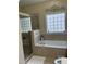Bright bathroom featuring a glass-enclosed shower and relaxing soaking tub beneath a decorative window at 119 Hunterwood Pl, Benson, NC 27504