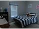 Cozy bedroom with a single bed, blue striped comforter, and window bringing in natural light at 119 Hunterwood Pl, Benson, NC 27504