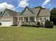 Charming single-story home showcasing a well-manicured lawn, neutral siding, and inviting front porch with stone accents at 119 Hunterwood Pl, Benson, NC 27504