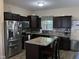 Modern kitchen with stainless steel appliances, granite countertops, and dark wood cabinets at 119 Hunterwood Pl, Benson, NC 27504
