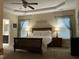 Serene main bedroom with tray ceiling, soft lighting, and ensuite bathroom access at 119 Hunterwood Pl, Benson, NC 27504