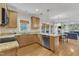 Open kitchen with wood cabinets, granite countertops, and stainless steel appliances, open to living area at 1237 Shirehall Park Ln, Wake Forest, NC 27587