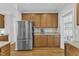 Kitchen area with wood cabinets, granite countertops, and stainless steel refrigerator at 1237 Shirehall Park Ln, Wake Forest, NC 27587