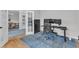Modern office space with a sit-stand desk, ergonomic chair, and sophisticated blue area rug at 1237 Shirehall Park Ln, Wake Forest, NC 27587