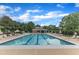 Enjoy the community pool on a sunny day, surrounded by lounge chairs and lush greenery at 1237 Shirehall Park Ln, Wake Forest, NC 27587