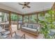 Cozy screened porch with a comfortable wicker sofa, ceiling fan, and natural light overlooking the wooded backyard at 1237 Shirehall Park Ln, Wake Forest, NC 27587