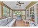 Relaxing sunroom featuring a comfortable wicker sofa, rocking chairs, and natural light pouring in from the large windows at 1237 Shirehall Park Ln, Wake Forest, NC 27587