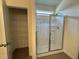 Bathroom with glass shower doors, tile flooring, and wire shelving at 128 Bruce Dr, Dunn, NC 28334