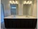 Modern bathroom featuring double sinks with a sleek vanity and dual mirrors at 128 Bruce Dr, Dunn, NC 28334