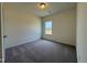 A carpeted bedroom featuring a neutral color palette and a window view at 128 Bruce Dr, Dunn, NC 28334