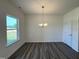 Dining room featuring wood-look floors, modern light fixture, and a large window at 128 Bruce Dr, Dunn, NC 28334