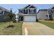 Two-story home with gray siding, a two-car garage, and a well-manicured front lawn at 128 Bruce Dr, Dunn, NC 28334
