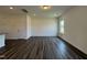 Light-filled living room with wood-look floors, a large window, and fresh white walls at 128 Bruce Dr, Dunn, NC 28334