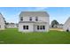 Exterior view of the back of the home with a well-maintained lawn and bright blue sky at 140 Benson Village Dr # 83, Benson, NC 27504