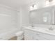 All white bathroom with double vanity, framed mirrors, bath tub, toilet and vinyl flooring at 140 Benson Village Dr # 83, Benson, NC 27504