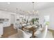 Stylish dining area features a modern light fixture, an elegant dining table with white chairs, and an open kitchen view at 140 Benson Village Dr # 83, Benson, NC 27504