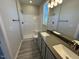 Bathroom featuring double sink vanity, framed mirror, and tiled walk-in shower at 140 Brookhaven Dr, Spring Hope, NC 27882