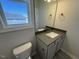 Bathroom features modern vanity with sink, toilet, and a window, blending style with functionality at 140 Brookhaven Dr, Spring Hope, NC 27882
