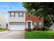 Charming two-story home with a combination of brick and siding exterior, showcasing a well-maintained lawn and a two-car garage at 1405 Merrilow Ct, Wake Forest, NC 27587