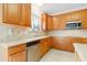 Charming kitchen featuring stainless steel dishwasher, microwave, tile backsplash, and light wood cabinets at 1405 Merrilow Ct, Wake Forest, NC 27587