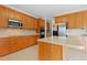 Bright kitchen featuring stainless steel appliances, island, tile backsplash, and light wood cabinets at 1405 Merrilow Ct, Wake Forest, NC 27587