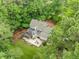 Aerial view of large home, beautiful backyard with brick patio and well-kept grounds surrounded by forest at 1501 Chatsworth Ln, Raleigh, NC 27614