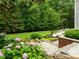 Stone steps leading to a grassy backyard with landscaped flower beds and lush foliage at 1501 Chatsworth Ln, Raleigh, NC 27614