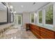 Bright bathroom features double sinks with granite countertop and custom wooden storage at 1501 Chatsworth Ln, Raleigh, NC 27614