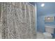 Bathroom featuring a shower with a decorative curtain, a toilet, and built-in shelves at 1501 Chatsworth Ln, Raleigh, NC 27614