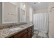 Bathroom features double vanity with granite countertop, wood cabinets, and shower-tub combination at 1501 Chatsworth Ln, Raleigh, NC 27614
