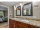 Bathroom with double sinks, granite countertop, wooden cabinets and decorative mirrors at 1501 Chatsworth Ln, Raleigh, NC 27614