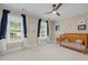 Bright Bedroom boasts a crib, ceiling fan, and large windows with views of the yard at 1501 Chatsworth Ln, Raleigh, NC 27614