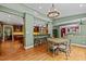 Open-concept dining area featuring hardwood floors, a modern light fixture, and a breakfast bar with wooden stools at 1501 Chatsworth Ln, Raleigh, NC 27614