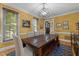 Bright dining room featuring wooden table with bench seating, large windows, and a modern chandelier at 1501 Chatsworth Ln, Raleigh, NC 27614