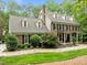 Beautiful brick home with shutters, dormer windows, professional landscaping, and an American flag in the driveway at 1501 Chatsworth Ln, Raleigh, NC 27614