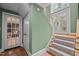 Hallway featuring a staircase with carpet runner, tile floors, and door with glass inserts for natural light at 1501 Chatsworth Ln, Raleigh, NC 27614