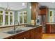 Bright kitchen featuring stainless steel appliances, island cooktop, wooden cabinetry, and scenic views at 1501 Chatsworth Ln, Raleigh, NC 27614