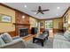 Cozy living room boasts a brick fireplace, ceiling fan, and comfortable seating arrangements at 1501 Chatsworth Ln, Raleigh, NC 27614