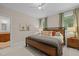 Comfortable main bedroom features a modern bed, windows with green curtains, and en-suite bathroom at 1501 Chatsworth Ln, Raleigh, NC 27614